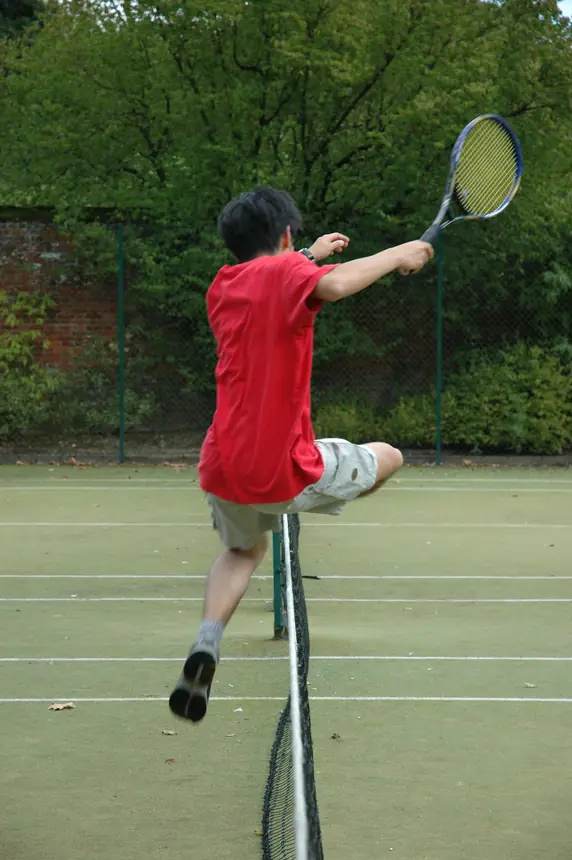 Tennis player leaping over the net